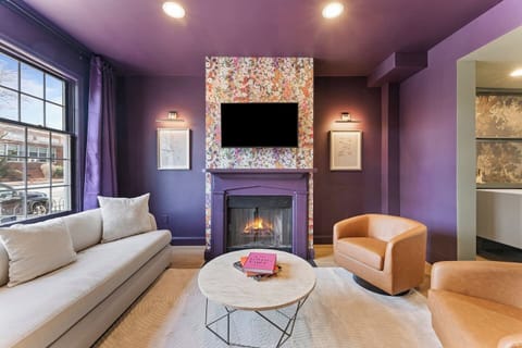 Stylish living room with bold tones, plush seating, and a statement feature wall—perfect for relaxing with friends or family