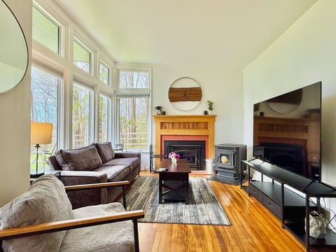 Natural light fills the room, complementing comfy seats and a big screen for movie nights.