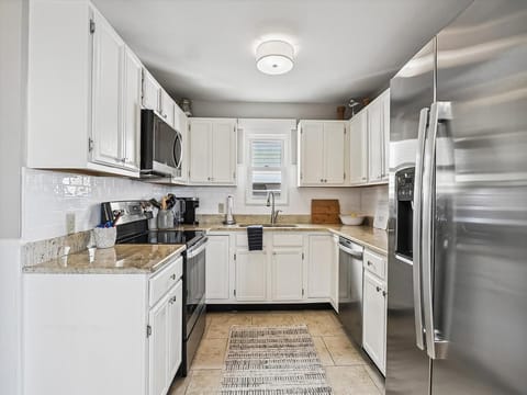 Fully equipped modern kitchen with stainless steel appliances.