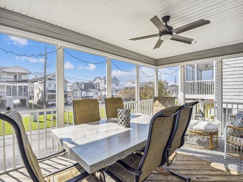 Screened-in porch with ceiling fans and a dining area, perfect for enjoying meals with a view, rain or shine.
