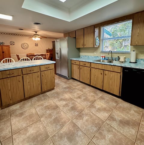 Enjoy cooking in this spacious kitchen with marble-style countertops, a double sink with a window view, full-size stainless steel fridge, dishwasher, and plenty of cabinet storage. Includes essentials like a regular coffee maker and toaster.