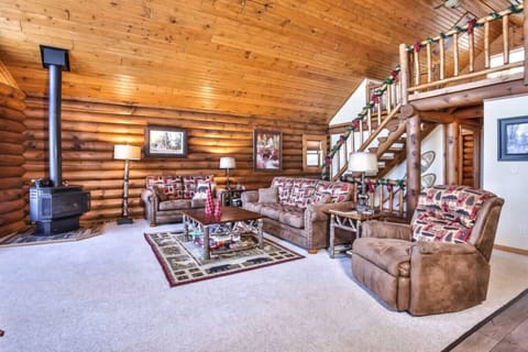 Gather in the warm glow of our log-beamed living room, where plush lodge-style sofas and a gas fireplace stove create the perfect setting for relaxing after a day on the lake or trails. The open lofted ceiling, natural woodwork, and Northwoods decor make 