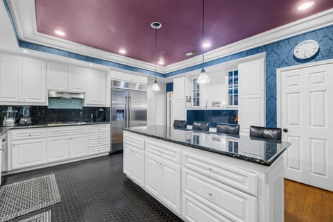 This stylish kitchen features sleek black granite, crisp white cabinetry, and bar seating for your whole crew.