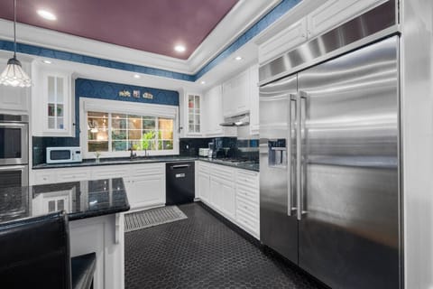 Enjoy garden views while cooking in a gourmet space equipped with top-tier appliances and charming design.