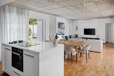 The fully equipped kitchen includes a kitchen island with a built-in sink, two ovens (gas and electric), a dishwasher, an ice maker, and a Dolce Gusto capsule coffee maker