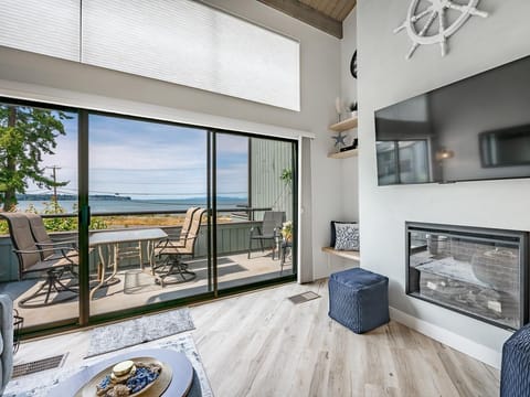 Sunlit living room with panoramic lake views and cozy fireplace