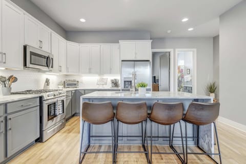 Discover this chic kitchen, perfect for gatherings after a night in Downtown Nashville. With luxury finishes and sleek appliances, it's ideal for brunches, bachelorette parties, family reunions, or upscale getaways—combining comfort and elegance for large groups in Music City.