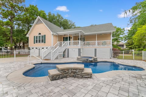 Beautiful vacation home with private pool surrounded by mature trees in peaceful neighborhood setting.