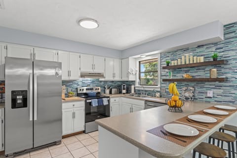 Fully equipped kitchen with stainless steel appliances, sleek open shelving, and plenty of counter space for cooking and gathering. Enjoy a morning coffee at the breakfast bar or prepare home-cooked meals with ease in this stylish, functional space.