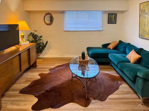 Relax in a cozy living room featuring a sleek TV and a stylish glass center table. It’s the perfect spot to unwind and feel right at home.
