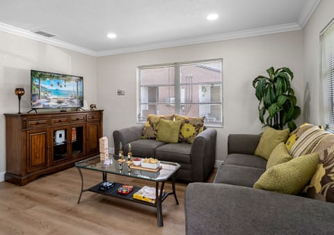 At the center of the room are two plush, soft grey couches, perfectly positioned to encourage relaxation, conversation, or a laid-back movie night.