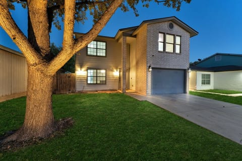 Front exterior with warm landscape lighting for a welcoming arrival.