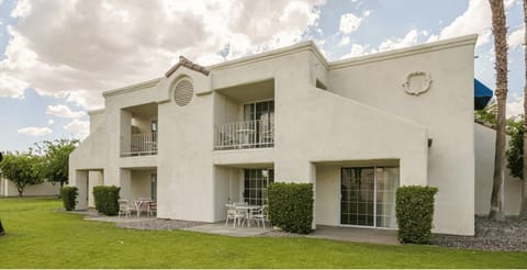 Discover the inviting exterior of this Palm Desert property, showcasing private patios and lush greenery, ideal for family gatherings and outdoor enjoyment.