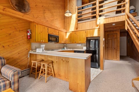This charming kitchen showcases rustic wooden cabinetry and a spacious countertop, perfect for both casual dining and meal preparation.