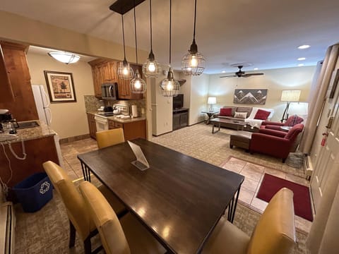 The spacious open-plan area combines a full kitchen and dining space, complete with modern appliances and ample seating for family meals, enhancing the cozy alpine experience.