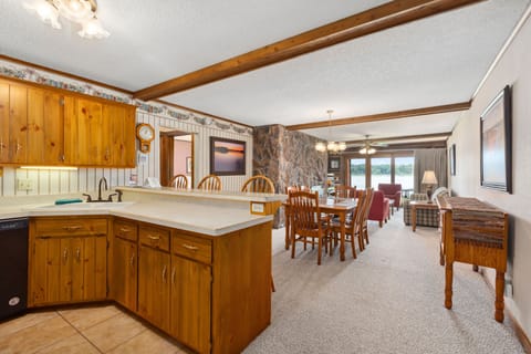 Fully equipped kitchen with wood cabinetry and breakfast bar next to the dining area.