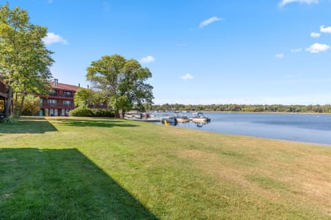 Expansive lawn area leading down to the calm waters of the lake.