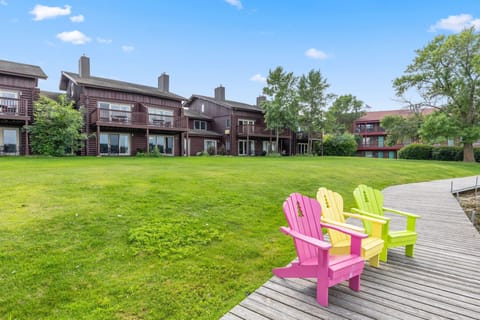 Spacious green lawn with colorful Adirondack chairs in front of the condos.