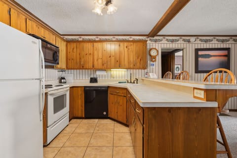 Full kitchen with wood cabinetry, modern appliances, and a center island.