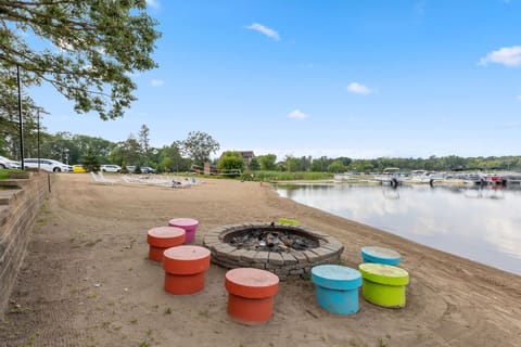 Experience serene lakeside gatherings by the cozy fire pit, surrounded by vibrant seating.