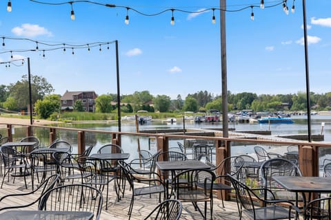 Lakeside patio with string lights and seating, perfect for outdoor dining by the water.
