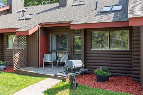Cabin exterior with private patio and red mulch landscaping.
