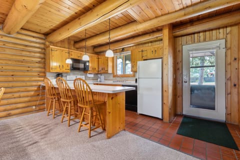 Rustic kitchen with warm wood cabinetry, breakfast bar, and modern appliances.