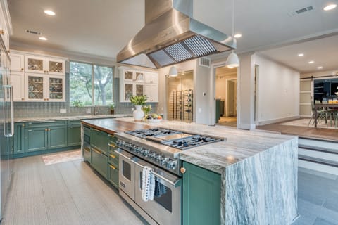Kitchen with stainless steel appliances and bar stools. (Main house)