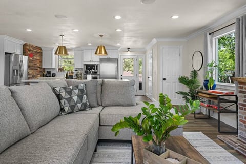 Open-concept comfort at its finest—relax on the oversized sectional, enjoy the fireplace glow, and whip up meals in the sleek, fully stocked kitchen just steps away.