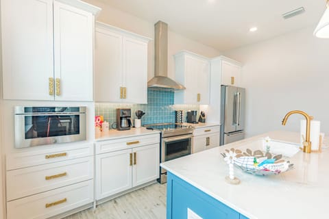 Bright and stylish kitchen with gold hardware, rich blue tile backsplash, and a breezy coastal-boho design that feels both modern and relaxed.