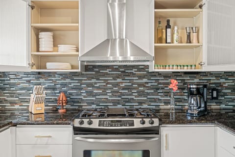 Fully-stocked kitchen: pots, pans, spices, utinsels, knives, coffee, and tea.