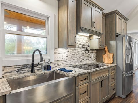 There's lots of sink space with this stainless sink which is in close proximiy to the 6 burner flat top range with pot filling faucet. 