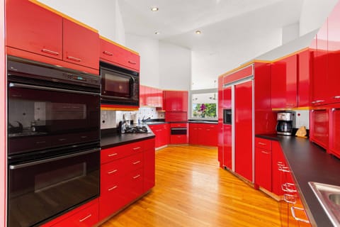 Gourmet Kitchen: Chef's paradise with vibrant red cabinetry and high-end appliances awaits your creations!