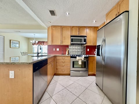This bright and functional kitchen features ample counter space for prepping meals, a full-size refrigerator, stove, oven, microwave, and dishwasher for easy clean-up.