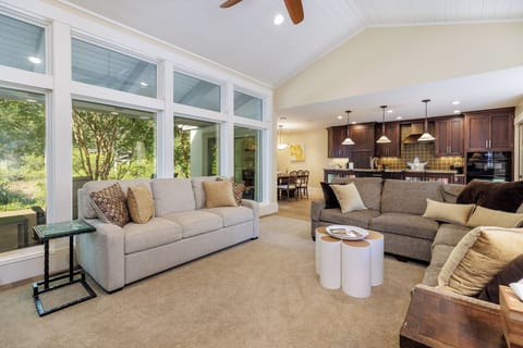 Large windows and sliding glass doors bring in natural light and open to tranquil lagoon views, creating a seamless indoor–outdoor feel.