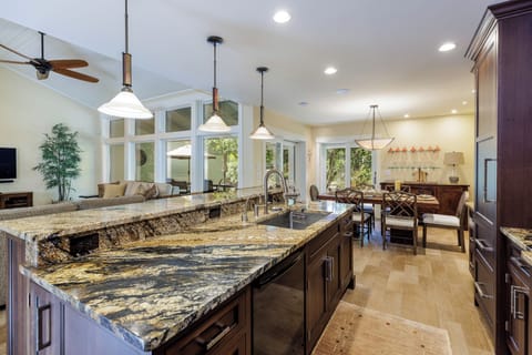 This beautifully appointed kitchen blends warmth and function with rich custom cabinetry, granite countertops, and ample prep space.