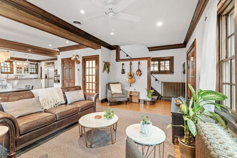 Relax in this charming living room where warm wood details, cozy leather seating, and musical touches create your perfect retreat.