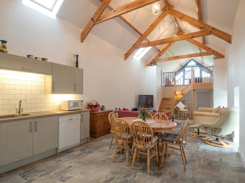 Kitchen, dining table and chairs into the open plan area and stairs to mezzanine bedroom