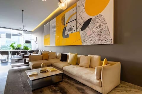 Bright living area w/ cozy sofa seating, bold wall art & open layout flowing into the kitchen
