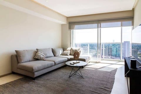 Spacious living room w/ sectional sofa & sliding doors to the balcony