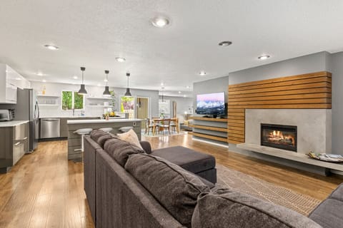 Living room with a gas fireplace, open to the kitchen and dining area.