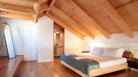 Embrace the rustic charm of exposed beams and natural light in this cozy attic loft, complete with a vintage-style vanity. #LoftLiving #RusticCharm #ArchitecturalDetails
