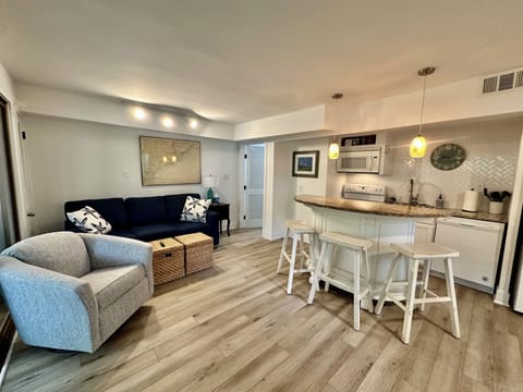 Living room with kitchen and island with 3 barstools