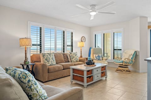 Sink into plush coastal comfort in your bright living space, where ceiling fans keep you cool and plantation shutters frame stunning views.