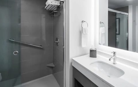 Refresh in a spotless, modern bath with bright vanity lighting.