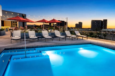 Dive into a glowing rooftop pool with city views.