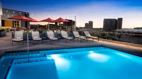 Dive into a glowing rooftop pool with city views.