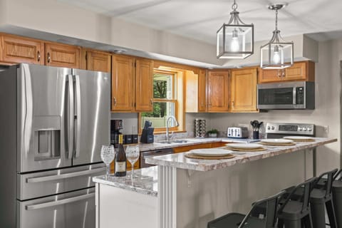 Fully stocked kitchen with 4 barstools at the breakfast bar, complimentary coffee and tea station, and visibility to the living room and back yard.