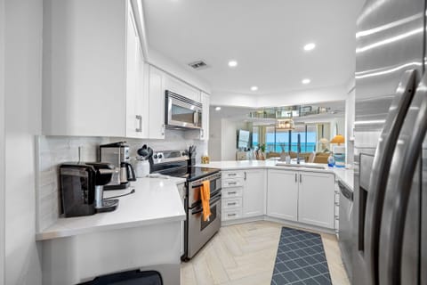 Open designer kitchen with a gulf view and stainless appliances