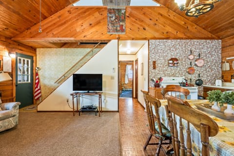 Charming living space with vaulted ceilings, recliners, and a flatscreen TV—ideal for movie nights at the lake. 🎬🔥🪵